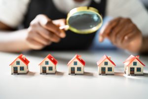 Homes under magnifying glass to signify home inspections.
